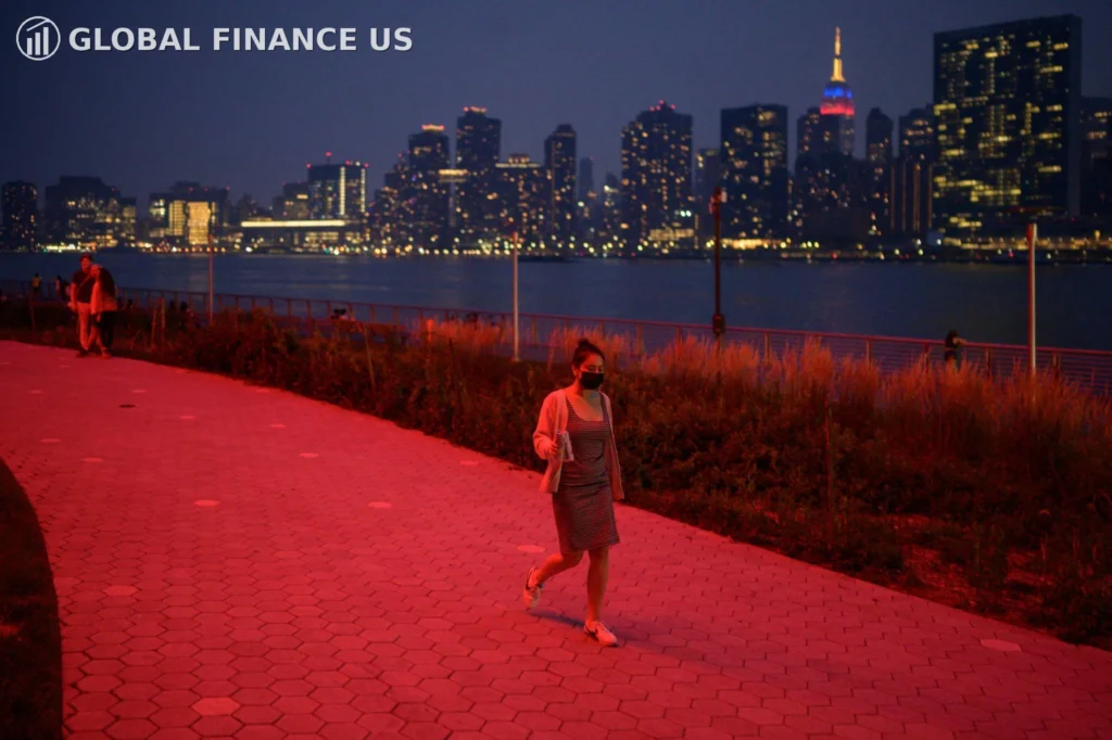 Urban air pollution at night with a woman wearing a face mask walking near a city skyline, showing the need to Protect Your Family from Pollution in America 2026
